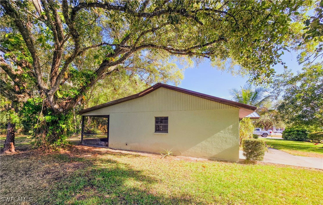 75 Hardee Street LaBelle, FL 33935 - Photo 3 of 24 a view of yellow house with a yard and large tree