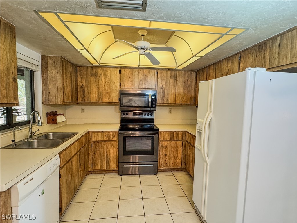 75 Hardee Street LaBelle, FL 33935 - Photo 9 of 24 a kitchen with granite countertop a sink and a refrigerator