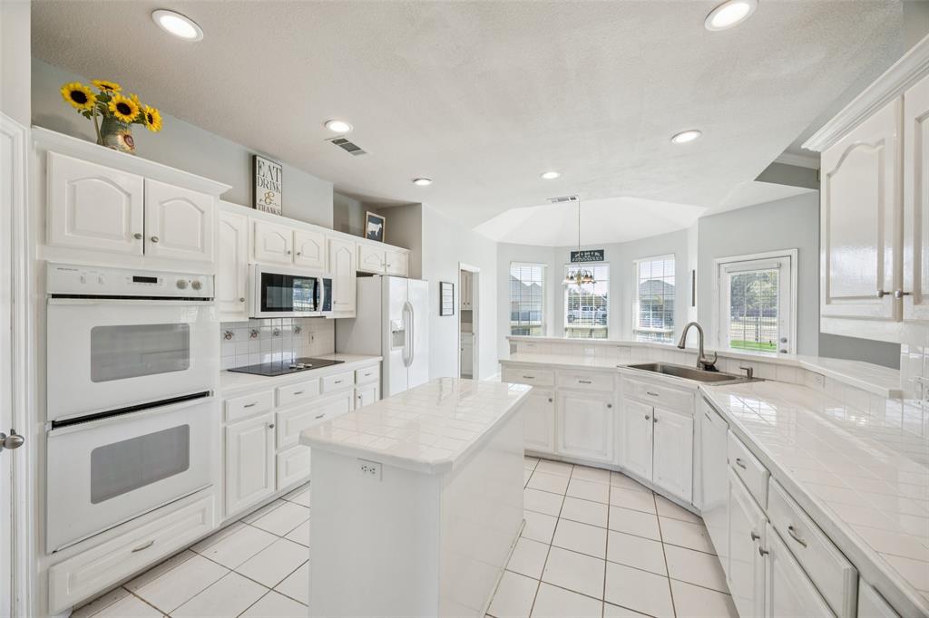 1107 Ruidoso Downs Drive Talty, TX 75160 - Photo 12 of 33 a kitchen with white cabinets and appliances