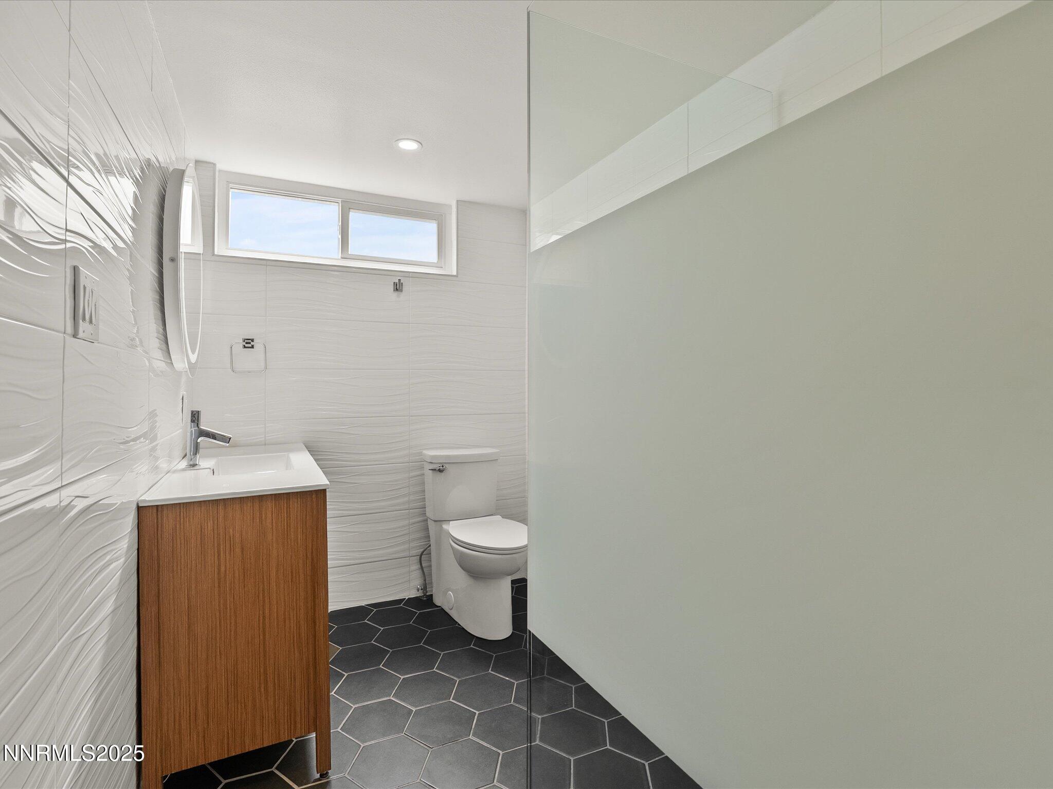 189 Ray Way Zephyr Cove, NV 89448 - Photo 23 of 71 a bathroom with a toilet sink vanity and mirror