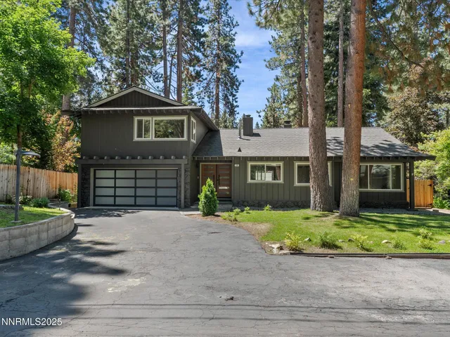 a view of an empty room with wooden floor and a fireplace