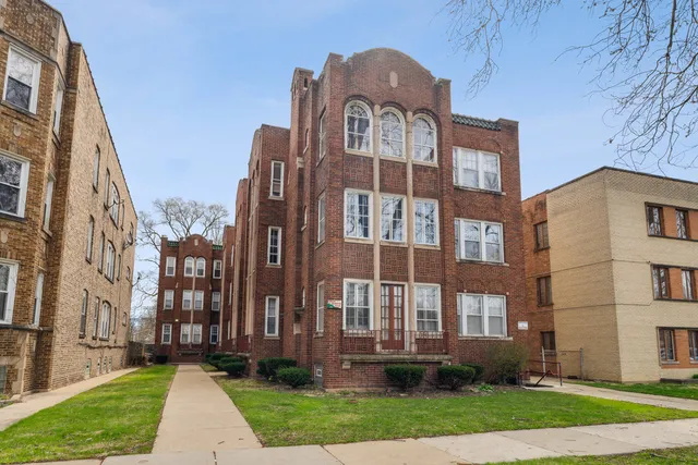 a view of a brick building next to a yard