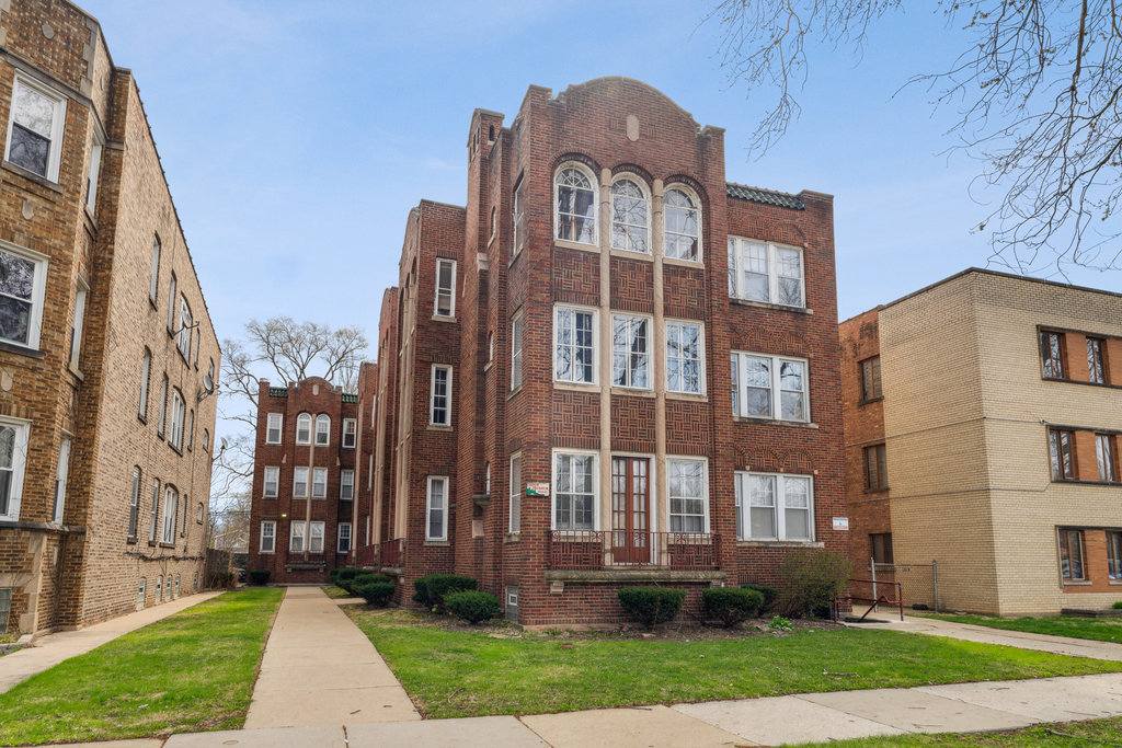 a view of a brick building next to a yard