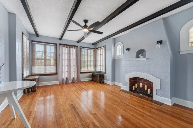 a view of an empty room with window and fire place