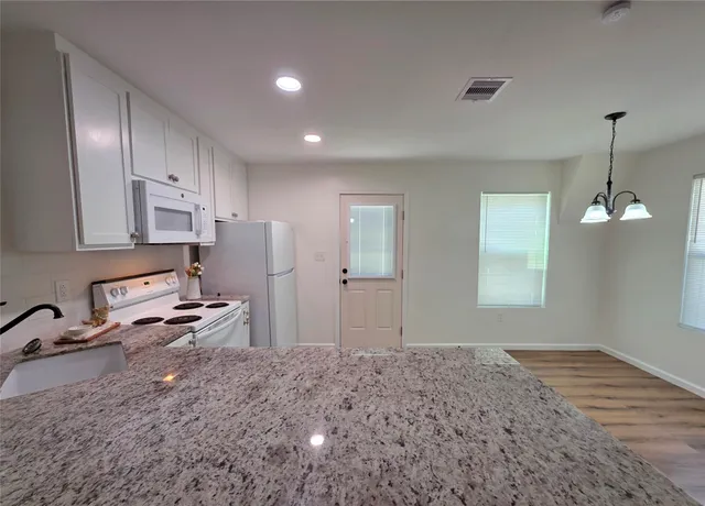 a kitchen with stainless steel appliances granite countertop a refrigerator and a stove top oven