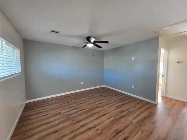 a view of an empty room with wooden floor