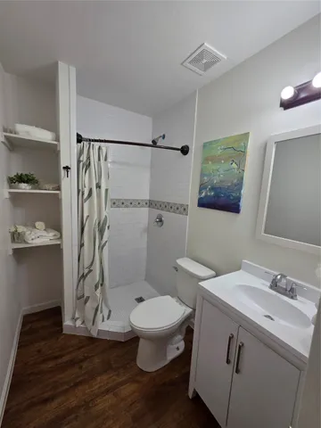 a bathroom with a granite countertop sink toilet and shower