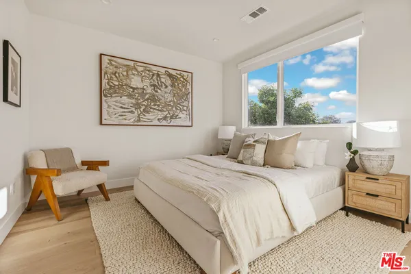 a bedroom with bed and a large window