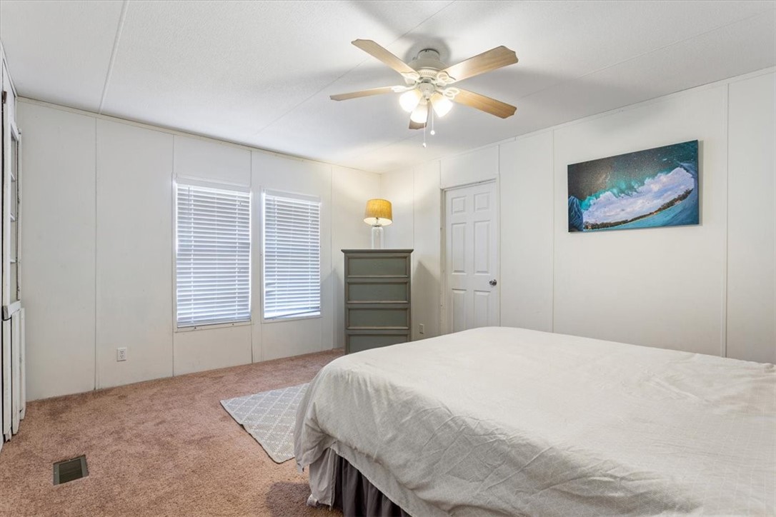 6067 Old Mexia Road Waco, TX 76705 - Photo 19 of 32 a bedroom with a large bed and a chandelier
