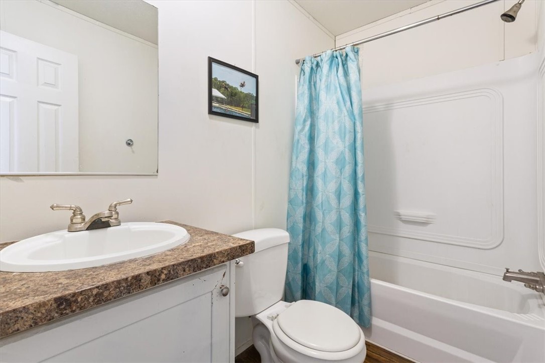 6067 Old Mexia Road Waco, TX 76705 - Photo 26 of 32 a bathroom with a granite countertop sink toilet and shower