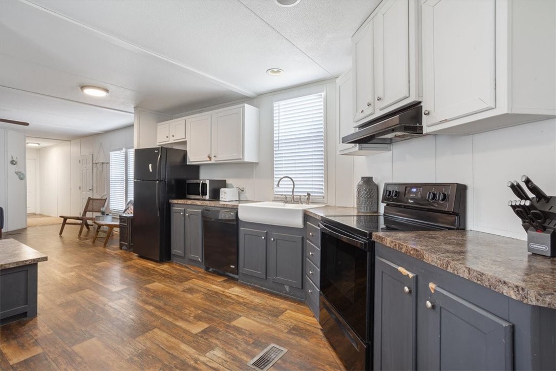 6067 Old Mexia Road Waco, TX 76705 - Photo 4 of 32 a kitchen with granite countertop a sink a counter top space appliances and cabinets