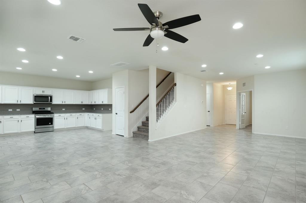 1409 Cliffbrake Way Georgetown, TX 78626 - Photo 3 of 10 Expansive open-concept living area featuring large format tile flooring, recessed lighting, and a modern ceiling fan