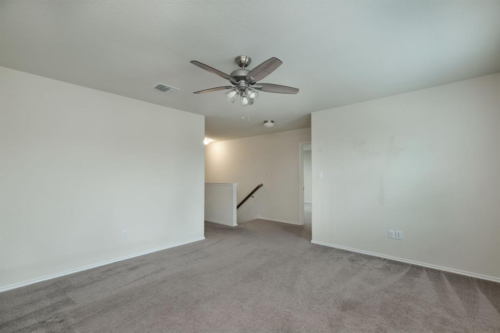 1409 Cliffbrake Way Georgetown, TX 78626 - Photo 5 of 10 Open room with plush gray carpet, clean white walls, and a contemporary ceiling fan with light fixture