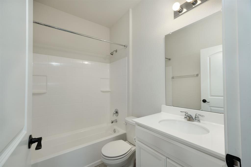 1409 Cliffbrake Way Georgetown, TX 78626 - Photo 9 of 10 Bathroom featuring a white vanity with a single basin sink, integrated countertop, and chrome fixtures