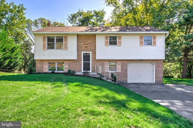 a front view of a house with a garden and yard
