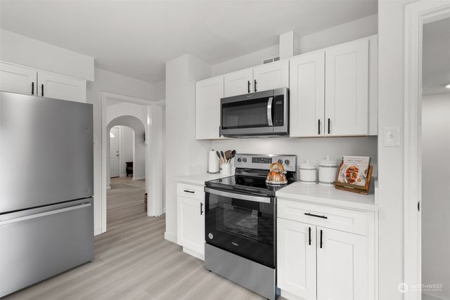 a kitchen with stainless steel appliances a stove microwave and sink