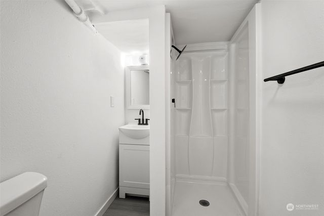 a bathroom with a shower a sink and toilet