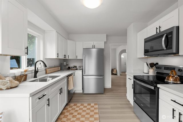 a kitchen with stainless steel appliances granite countertop a refrigerator stove and sink