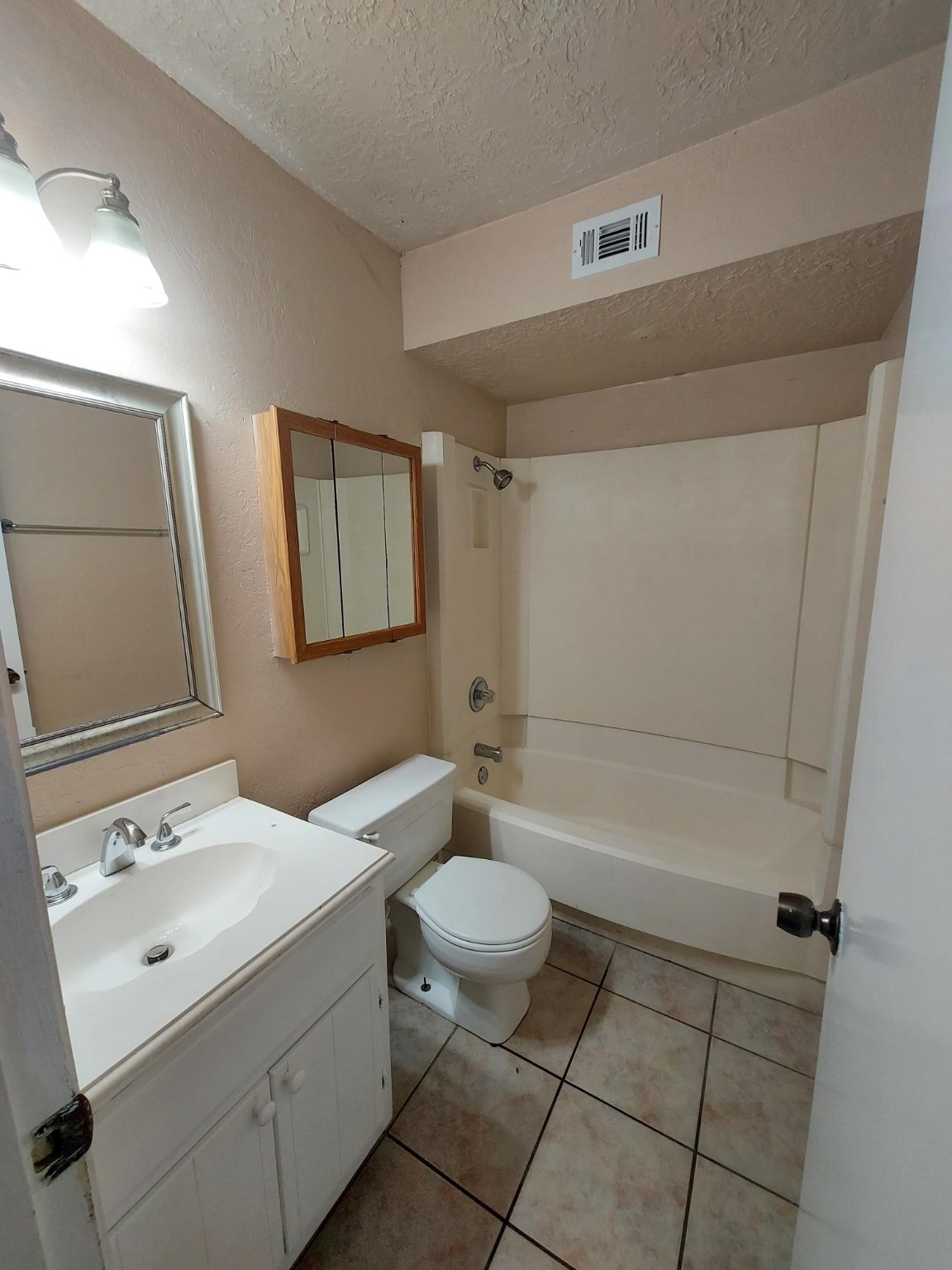 13433 Castilian Drive, Unit 1 Houston, TX 77015 - Photo 6 of 10 a bathroom with a sink a toilet and shower