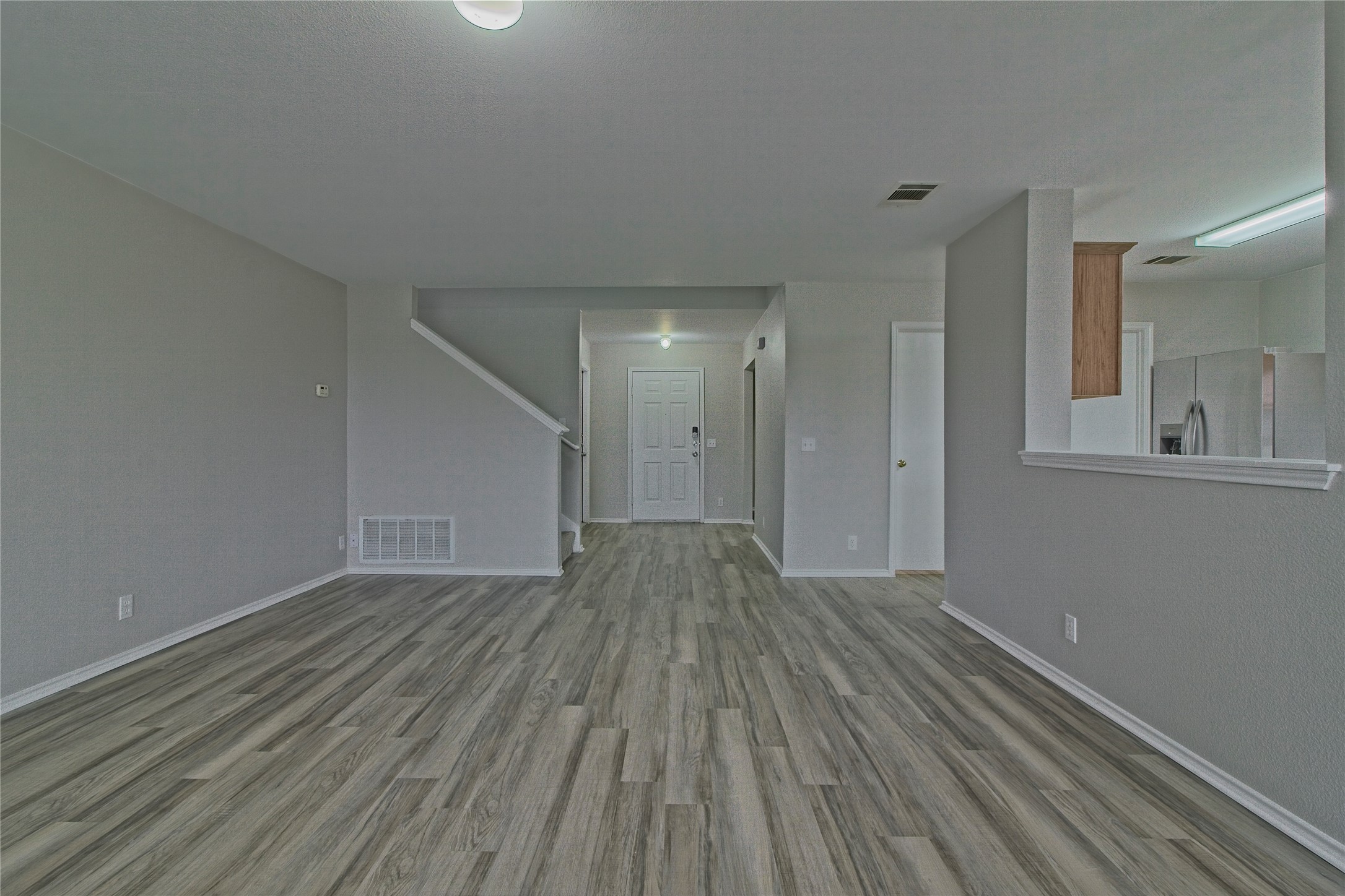 232 Brickyard Lane Jarrell, TX 76537 - Photo 5 of 31 A seamless flow of wood-look flooring connects the welcoming entrance foyer with the spacious living area.