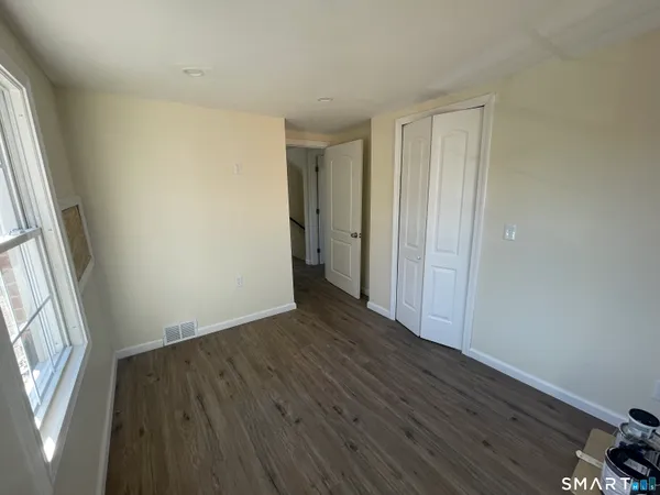 an empty room with wooden floor and a window