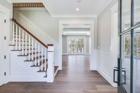 an empty room with wooden floor fireplace and windows