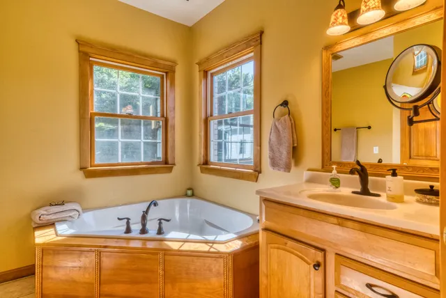 a bathroom with a tub sink and mirror