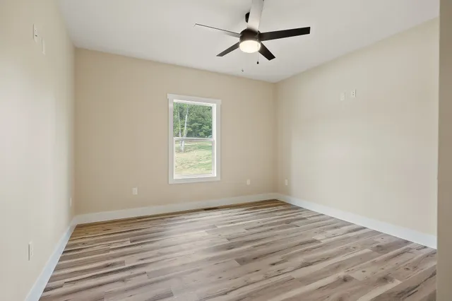wooden floor in an empty room with a window