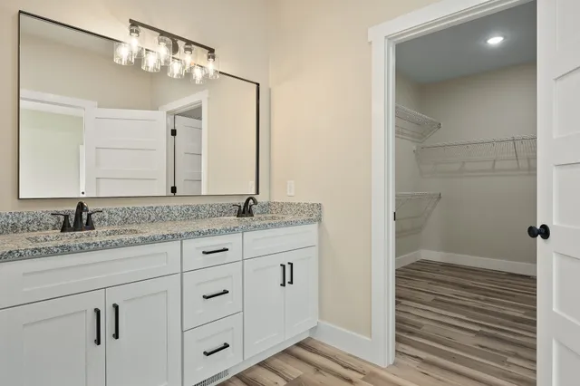 a bathroom with a granite countertop sink and a mirror