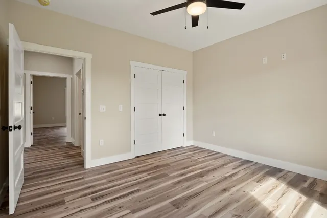 a view of a room with wooden floor and ceiling fan