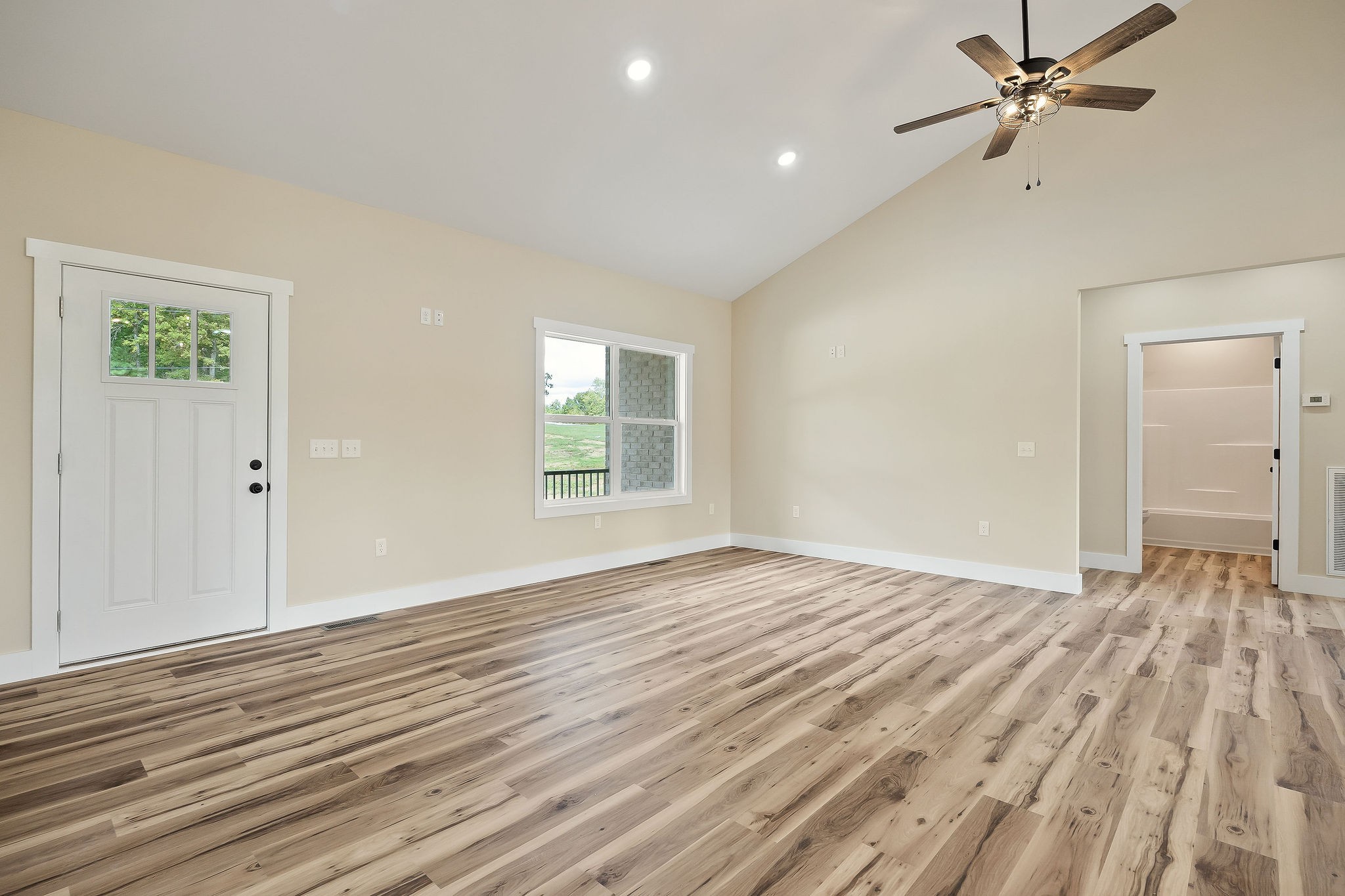 6544 Thomas Twin Oaks Road Baxter, TN 38544 - Photo 4 of 32 an empty room with wooden floor ceiling fan and windows
