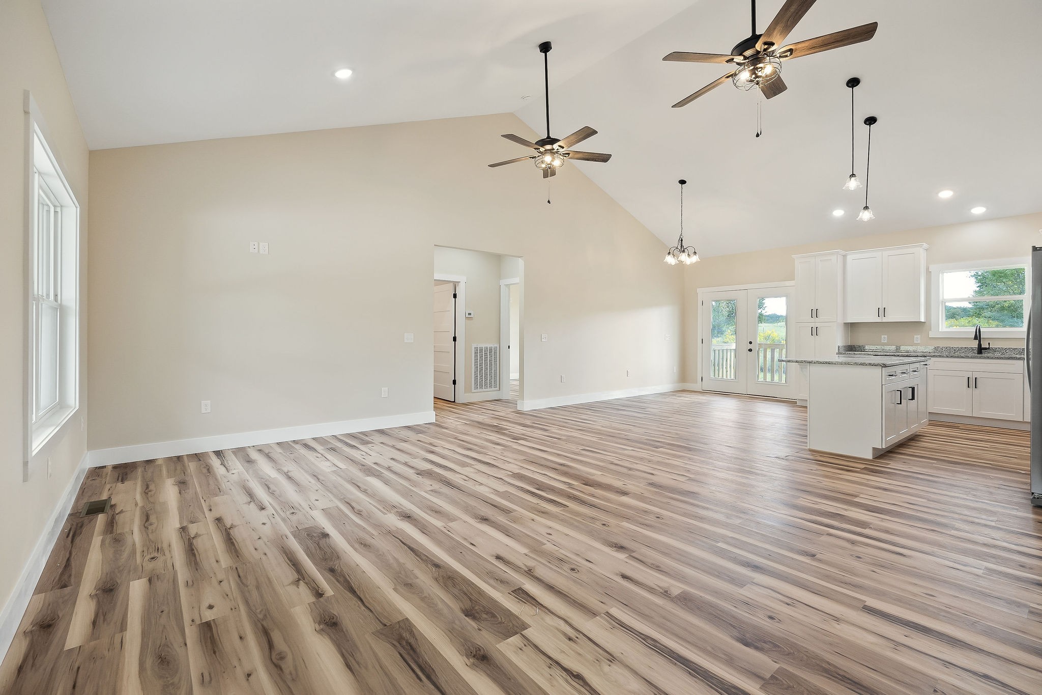 6544 Thomas Twin Oaks Road Baxter, TN 38544 - Photo 6 of 32 an empty room with wooden floor an entryway and windows
