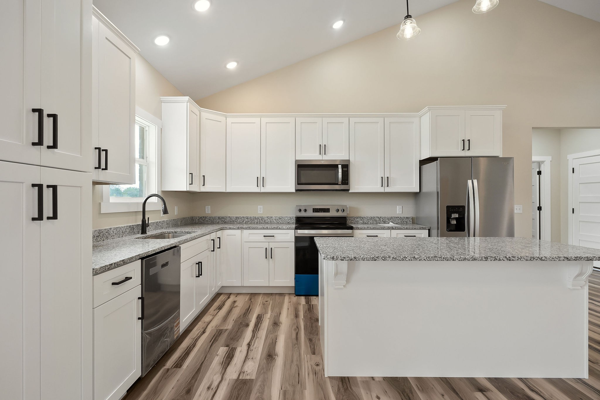 6544 Thomas Twin Oaks Road Baxter, TN 38544 - Photo 7 of 32 a large kitchen with stainless steel appliances granite countertop a stove a sink a refrigerator and white cabinets with wooden floor