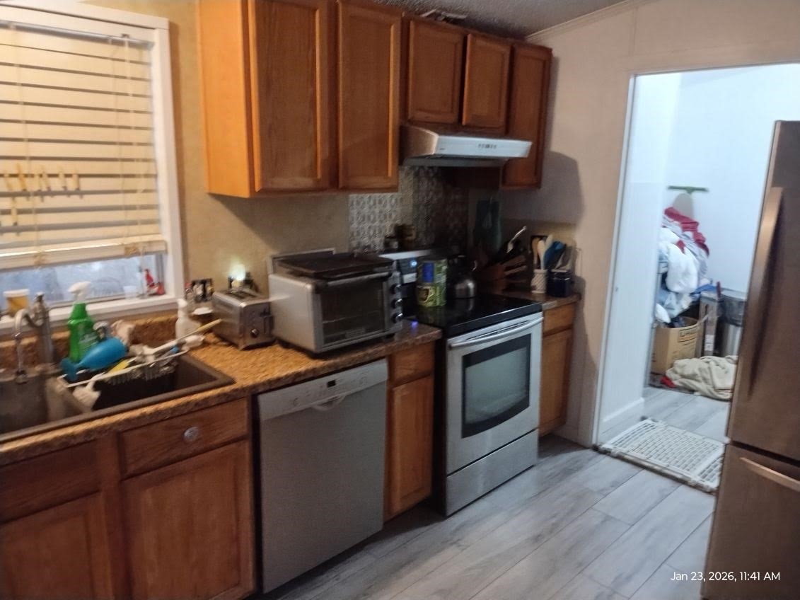 180 Woods Road Coldspring, TX 77331 - Photo 3 of 35 a kitchen with a sink cabinets and stainless steel appliances