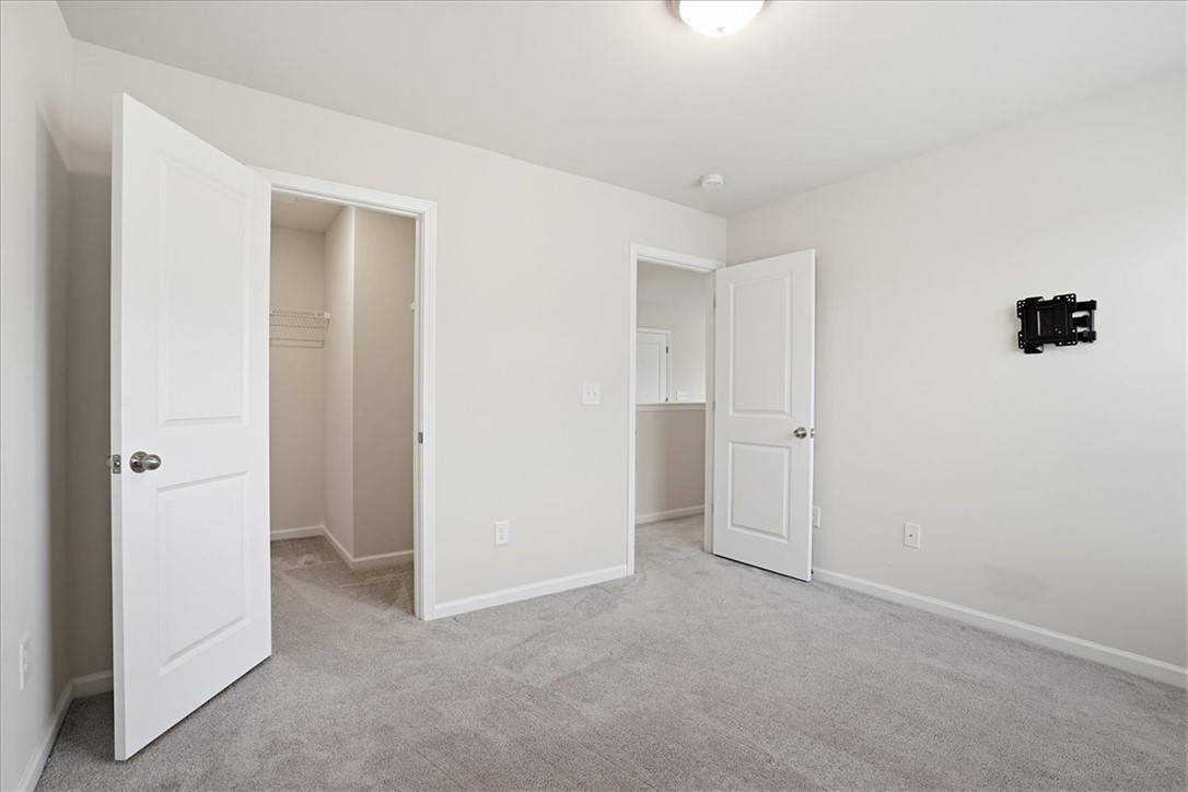 365 Sliding Rock Drive Pendleton, SC 29670 - Photo 18 of 46 A well-lit bedroom with neutral walls and soft gray carpeting offers a blank canvas for personalization.