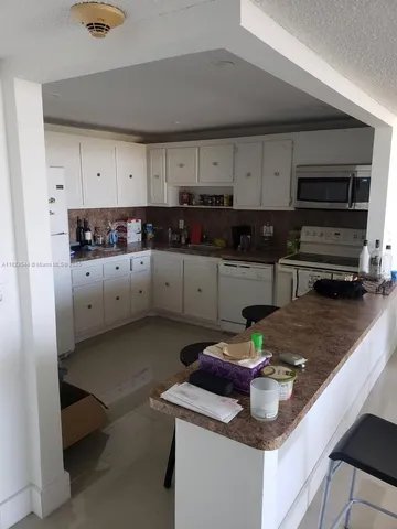 a kitchen with stainless steel appliances granite countertop a sink and a stove