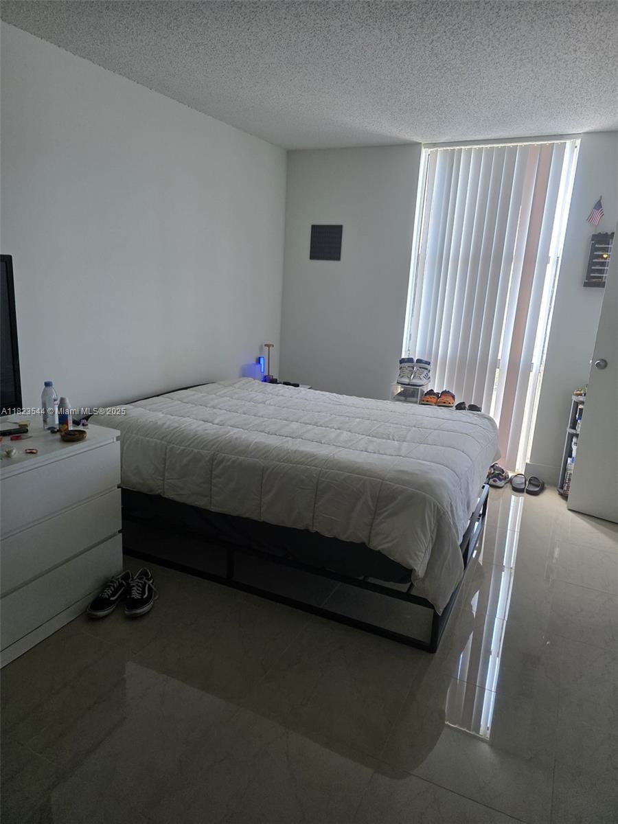 13499 Biscayne Boulevard, Unit 1005 North Miami, FL 33181 - Photo 8 of 15 a bedroom with a bed and window
