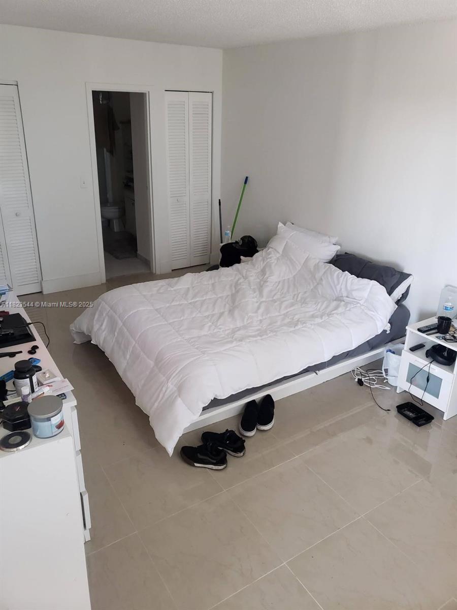 13499 Biscayne Boulevard, Unit 1005 North Miami, FL 33181 - Photo 9 of 15 a bedroom with a bed and a dresser