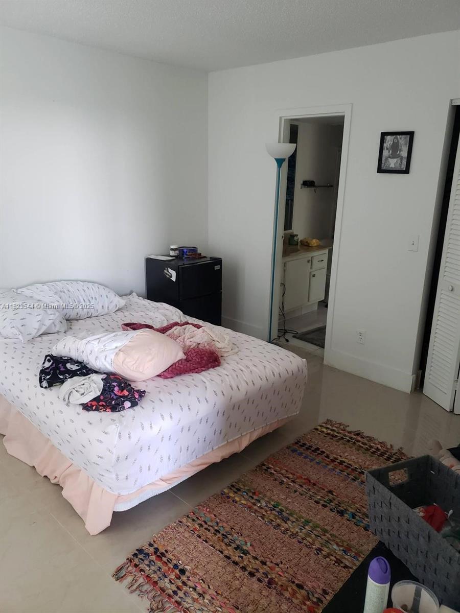 13499 Biscayne Boulevard, Unit 1005 North Miami, FL 33181 - Photo 10 of 15 a bedroom with a bed and wooden floor