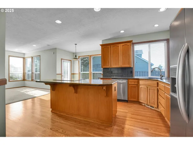 a kitchen with stainless steel appliances granite countertop a sink stove and cabinets