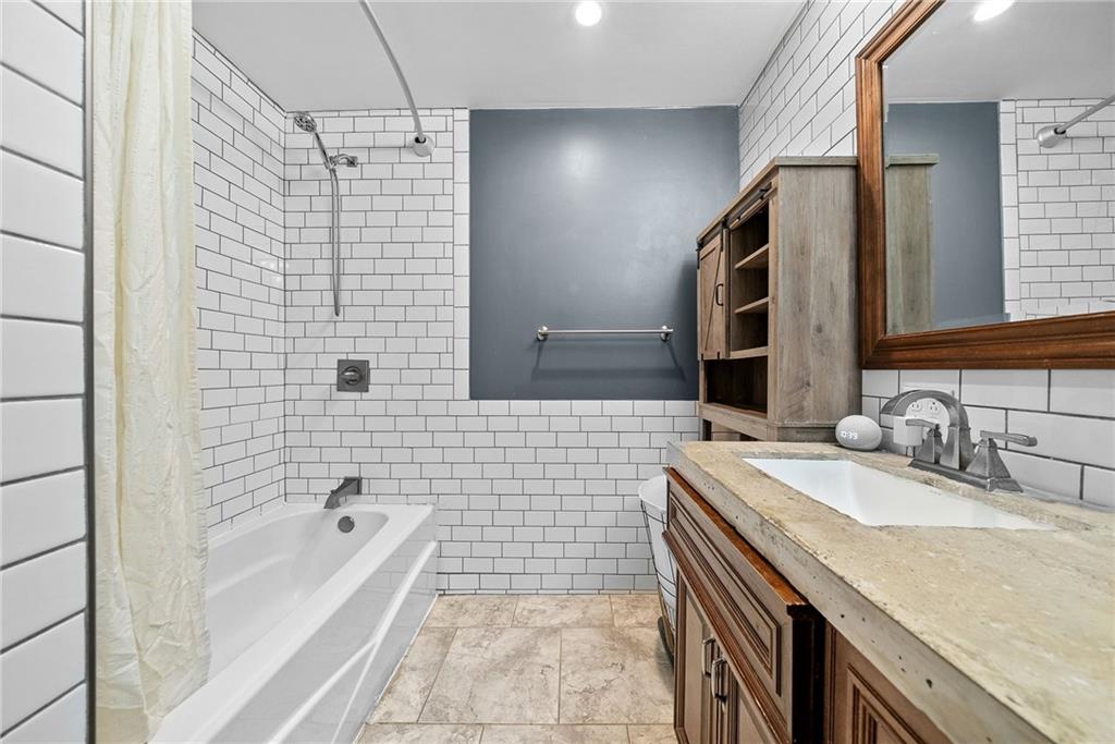 449 Elwyn Avenue Springdale, PA 15144 - Photo 29 of 46 a bathroom with a granite countertop sink a toilet a mirror and bathtub