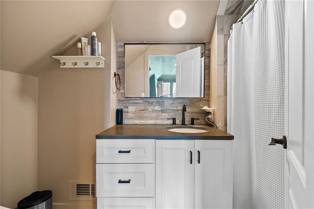 449 Elwyn Avenue Springdale, PA 15144 - Photo 38 of 46 a bathroom with a sink a mirror and a window