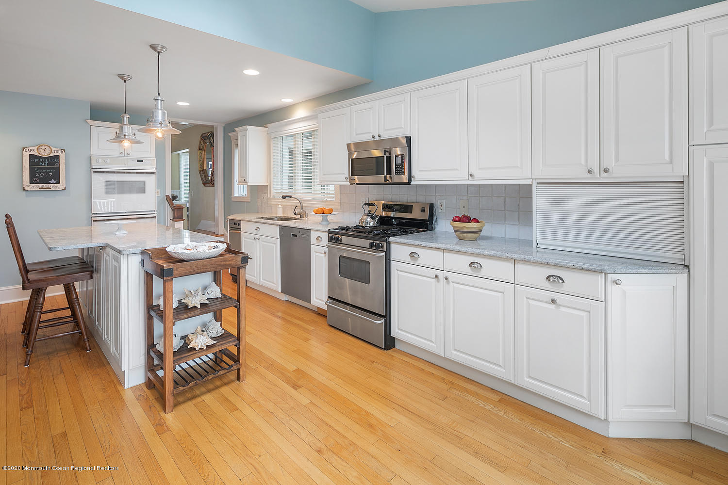 408 Tuttle Avenue Spring Lake, NJ 07762 - Photo 17 of 36 a kitchen with white cabinets stainless steel appliances and wooden floor