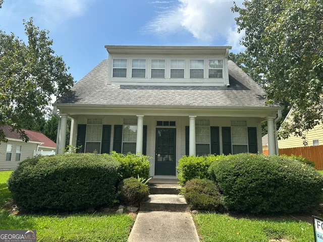 a front view of a house with a garden