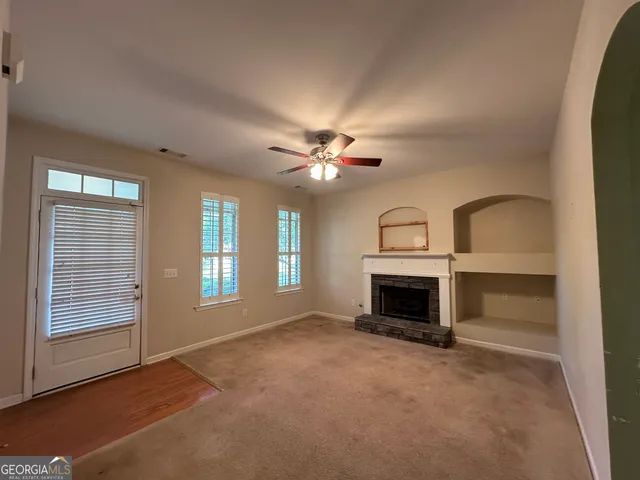 wooden floor fireplace and windows in an empty room