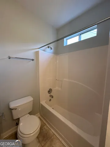 a white toilet sitting next to a bath tub and a shower
