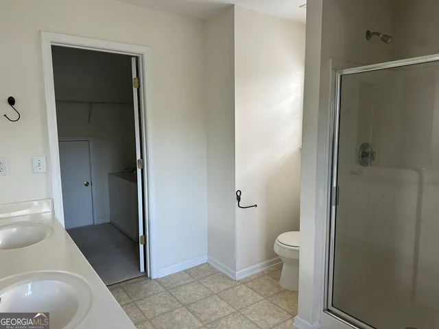 a bathroom with a granite countertop toilet and a sink