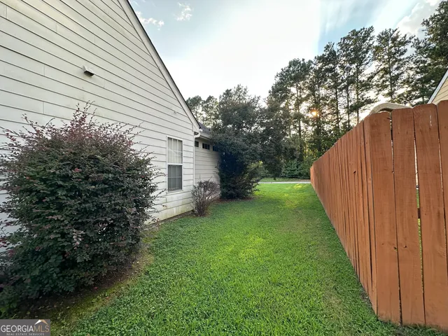a view of a backyard with potted plants and large tree