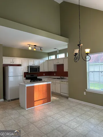 a open kitchen with stainless steel appliances granite countertop a sink a stove top oven and refrigerator