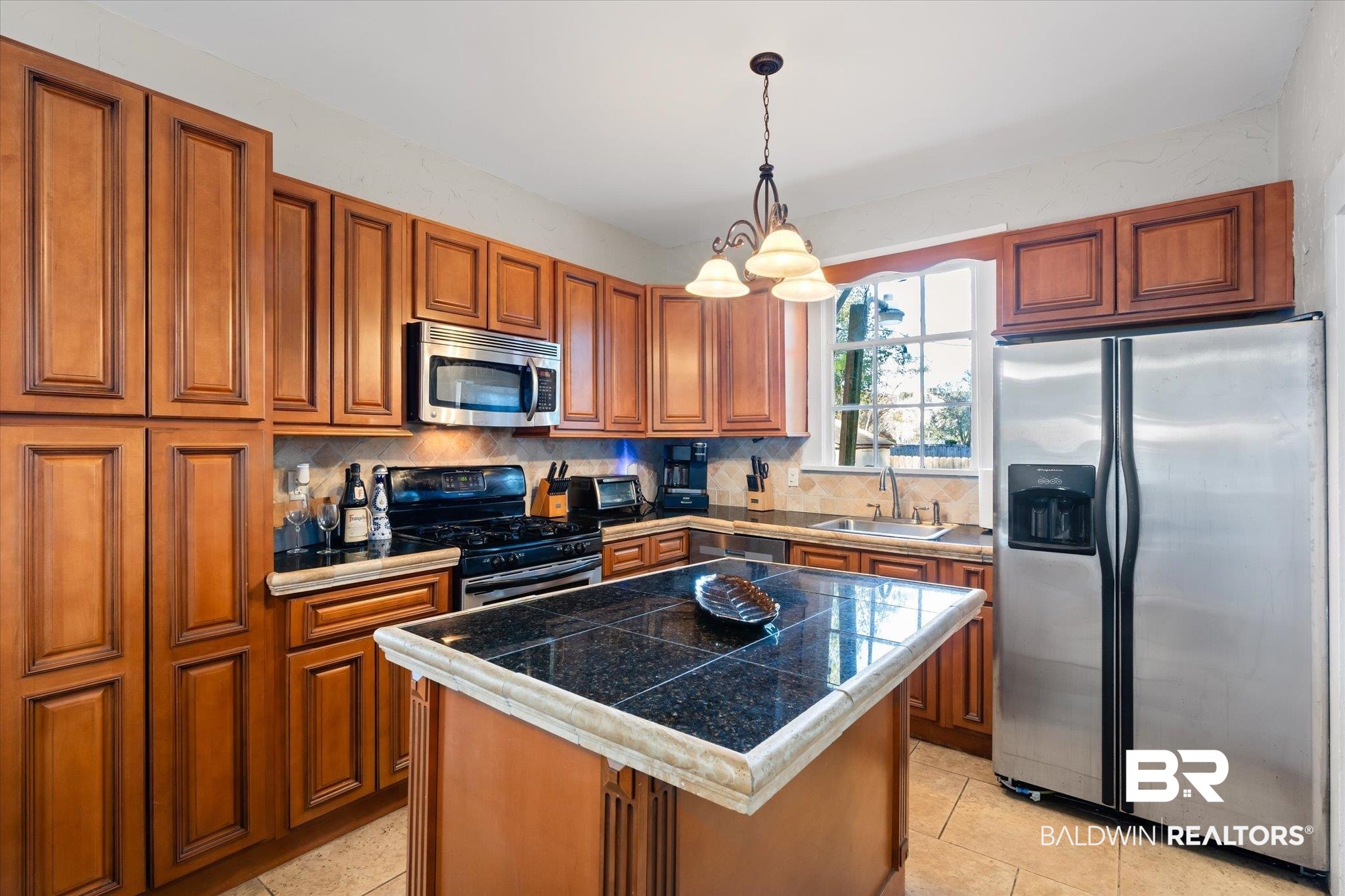 7 Rickarby Place Mobile, AL 36606 - Photo 9 of 20 Kitchen featuring appliances with stainless steel finishes, backsplash, sink, pendant lighting, and a center island